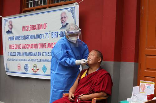 En India, un trabajador sanitario toma una muestra a un monje tibetano exiliado durante la jornada gratuita por el cumpleaños 71 del primer ministro, Narendra Modi. Foto Afp
