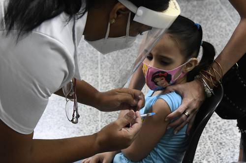 En una escuela de La Habana, una niña es inmunizada por una trabajadora de la salud con el antígeno Soberana 2.