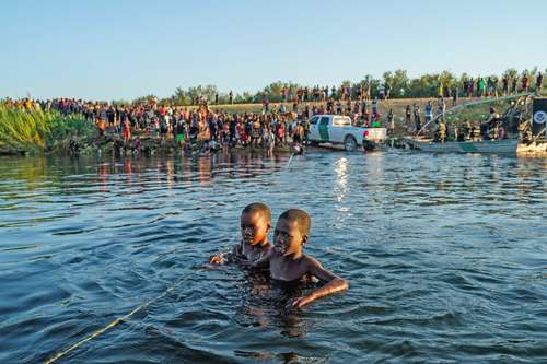 Dos niños haitianos intentan cruzar el río Bravo hacia Texas, en imagen tomada desde Ciudad Acuña, Coahuila.