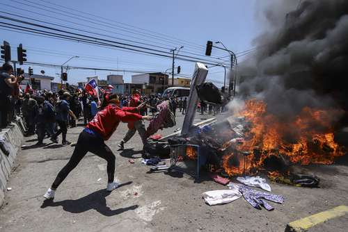 Manifestantes quemaron las pertenencias de migrantes venezolanos y colombianos que acampaban en las calles de Iquique.