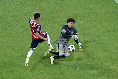 El portero Guillermo Ochoa impide que Uriel Antuna controle el balón.