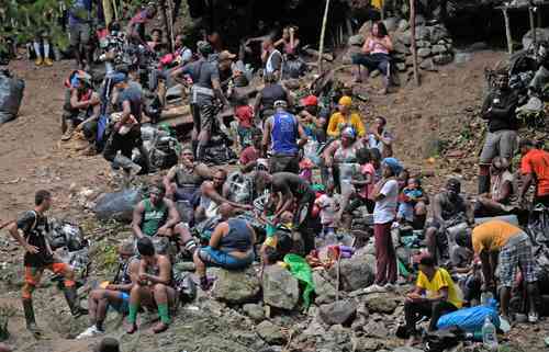 Haitianos descansan en la selva del Darién, en Colombia, en su trayecto rumbo a Panamá y Estados Unidos como meta final.
