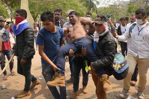 Manifestantes indígenas auxilian a un compañero herido durante enfrentamientos con la policía por el arresto de un líder tribal, luego de que los legisladores aprobaron una ley que criminaliza las invasiones de tierras, en Asunción, Paraguay. La ley afecta a varias comunidades originarias que residen en asentamientos improvisados a la espera de la restitución de sus tierras, y ayer fue promulgada por el gobierno del presidente Mario Abdo Benítez.