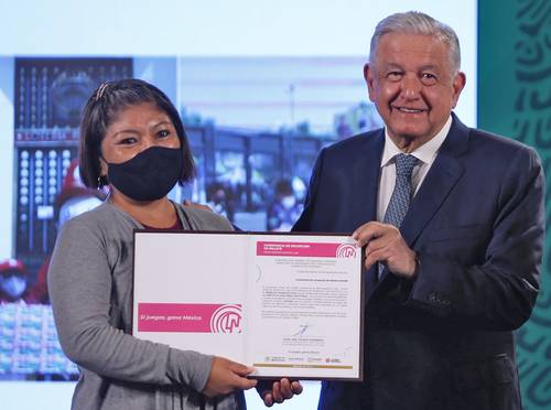 El presidente Andrés Manuel López Obrador entregó a Nereida Morales un documento que la acredita como ganadora de un rancho en el sorteo de la Lotería Nacional del 15 de septiembre.