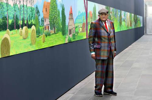 El pintor británico David Hockney posa en el Museo de la Orangerie en París, frente a su obra Un año en Normandía, un friso de 91 metros pintado en el encierro de 2020. El artista realizó un centenar de dibujos en el iPad en los que capturó los efectos de la luz y el clima de las cuatro estaciones.