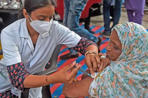 s Una trabajadora de la salud inocula a una mujer en Ahmedabad, India, país que ha batido récords de vacunaciónen las últimas semanas. Foto Afp
