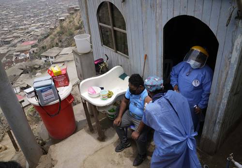 Durante una jornada de vacunación casa por casa en Lima, Perú, Wilber Guzmán, del barrio Villa María del Triunfo, recibe la dosis de Sinopharm.