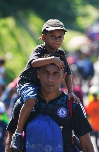 Dos integrantes de la caravana por la justicia, la dignidad y la libertad del pueblo migrante, al llegar ayer a Villa Comaltitlán, Chiapas, donde pernoctaron antes de seguir su camino hacia Estados Unidos.