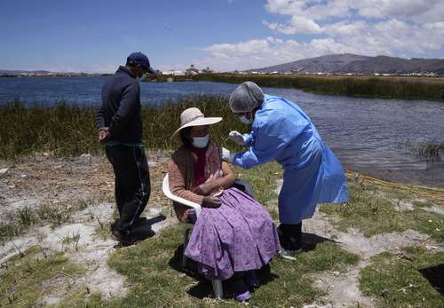 Trabajadores peruanos de la salud realizan una campaña de vacunación a domicilio en la costa del lago Titicaca en Puno.
