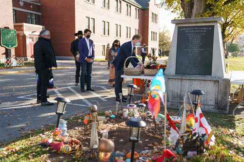 En imagen de archivo del 18 de octubre pasado, el premier Justin Trudeau (centro) y el ministro de Servicios Indígenas, Marc Miller (derecha) colocan una ofrenda floral en un monumento fuera del internado escolar de Kamloops, donde fueron hallados los restos de 215 niños indígenas en tumbas anónimas.