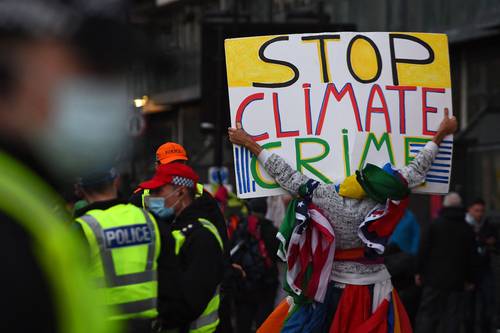 “Alto al crimen climático”, clama un manifestante en las inmediaciones de la sede de la COP26, encuentro que concluye este fin de semana.
