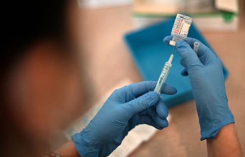  En Londres, una enfermera prepara la tercera dosis de Moderna para inmunizar a mayores de 18 años. Foto Afp