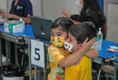 Una niña conforta a su hermano durante la campaña de inoculación con Sinovac a menores de 3 a 5 años en Santiago de Chile.