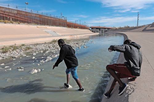 Migrantes cruzan el río Bravo, en la frontera de Ciudad Juárez con El Paso, Texas, donde se espera que desde hoy lleguen los primeros extranjeros devueltos para esperar respuesta a su solicitud de asilo.