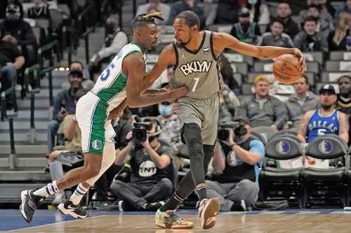 El delantero de los Mavericks Reggie Bullok en posición defensiva, mientras Kevin Durant (7) prepara un tiro en la primera mitad del partido.