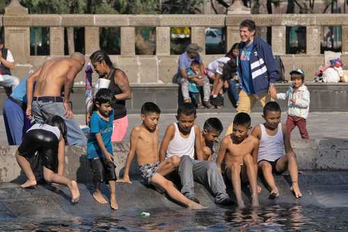 Como si fuera verano, niños y adultos se dieron cita en la Alameda Central de la Ciudad de México para darse un chapuzón en una de sus fuentes.