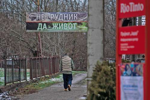 Un activista medioambiental pasa bajo un cartel de protesta junto a la oficina de la empresa minera anglo-australiana Rio Tinto, que planea construir una mina para la explotación de litio en la aldea de Gornje Nedeljice, en Serbia.