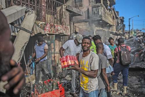 Tras el estallido de un camión cisterna que llevaba gasolina, los residentes de Cabo Haitiano sacaron mercancías de un depósito que resultó afectado.