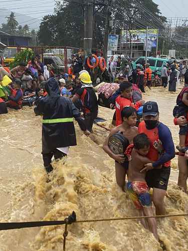 Rescatistas auxilian a la población de Cagayán de Oro cuyas viviendas quedaron bajo el agua tras el paso del tifón Rai.