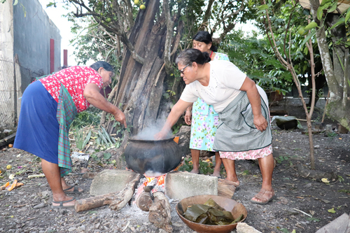 Mujeres nahuas sacan tamales recién hechos.