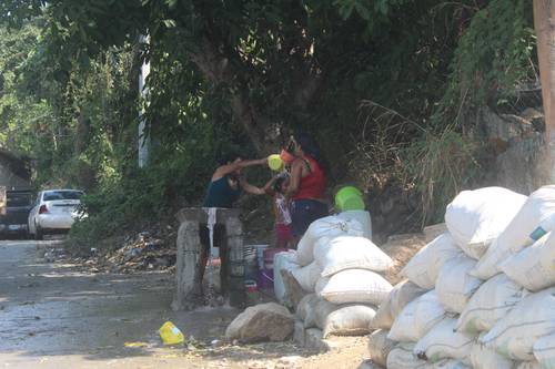 Alma Hernández y sus hijas, habitantes de la colonia Altos del Tamarindo, en Acapulco, Guerrero, se abastecen de agua cada 15 días en un pozo cerca de la calzada Pie de la Cuesta, pues en su casa no hay red hidráulica.