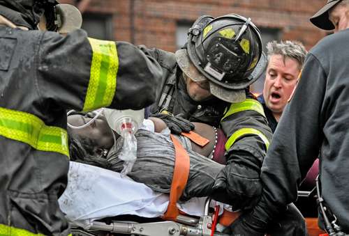 Un integrante de la cuadrilla de bomberos realiza reanimación cardiopulmonar a una de las víctimas desalojadas del multifamiliar de 19 pisos en East 181 Street, en el barrio del Bronx de Nueva York.