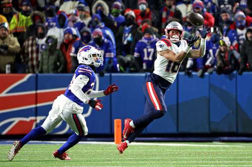 Jakobi Meyers, de los Patriotas, atrapa el balón al superar a Taron Johnson, de los Bills de Búfalo, durante el segundo cuarto en el juego de playoffs.