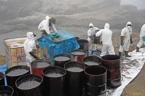 Trabajadores retiran petróleo derramado en la playa Cavero, en Perú. Repsol asegura que se trata de un accidente tras el oleaje creado por la erupción de un volcán en Tonga.
