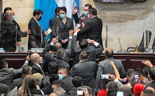 El ministro hondureño de Gobernación, Leonel Ayala, toma juramento como presidente del Congreso a Jorge Cálix, entre protestas de miembros de la alianza Libre. Cálix fue propuesto por 20 diputados disidentes de la coalición que respalda a la gobernante electa, Xiomara Castro.