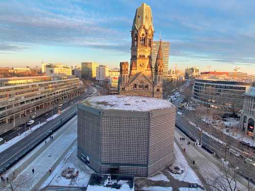 La iglesia de la Memoria en Berlín, la ruina en contraste con la iglesia nueva; detrás, las grúas que caracterizan a la capital como ciudad en permanente construcción.