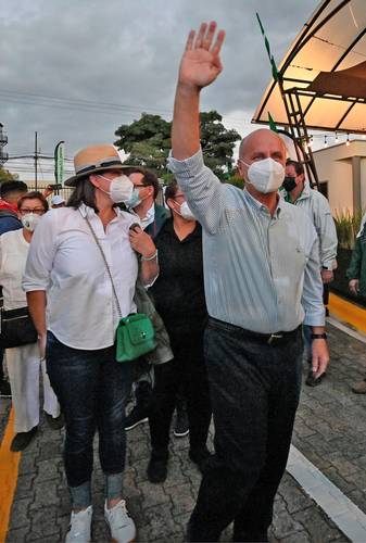 José María Figueres, candidato del Partido Liberación Nacional, saluda a simpatizantes al llegar a su casa de campaña, acompañado de su esposa Cinthia Berrocal.