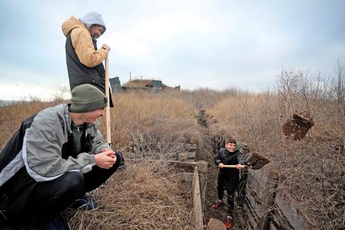 Adolescentes ucranios cavan trincheras para los soldados que sirven en el frente oriental de su país y enfrentan a los separatistas respaldados por Rusia, cerca de la aldea de Chervone, región de Mariupol, en el este de Ucrania.