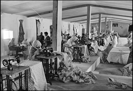 República Árabe Saharaui Democrática, 1982. Hombres y mujeres refugiados en el campamento de Tinduf, Argelia, se dedican a la producción de ropa en una fábrica para el consumo saharaui.  Pedro Valtierra