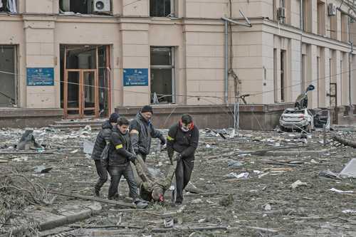 Voluntarios ucranios rescatan a una víctima del edificio del ayuntamiento, luego del bombardeo en Jarkov.