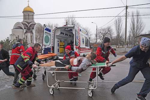 Paramédicos trasladan a un hombre herido por bombardeos en una zona residencial hacia un hospital de maternidad convertido en sala médica y utilizado como refugio antiaéreo en Mariupol.