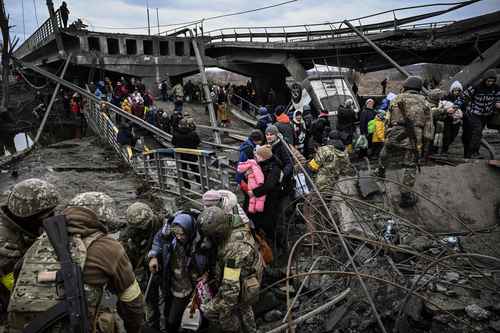 En la ciudad de Irpin, al noroeste de Kiev, pobladores buscaron huir a través de un puente destruido. Foto Afp