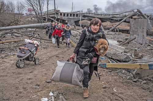 Ucranios abandonan este domingo la ciudad de Irpin –cerca de Kiev– mediante un sendero improvisado junto a un puente destruido.