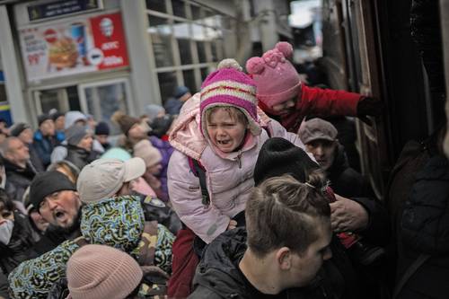 Familias luchan, ayer en Kiev, por abordar el tren hacia Leópolis, en el este de Ucrania, a 70 kilómetros de la frontera con Polonia.