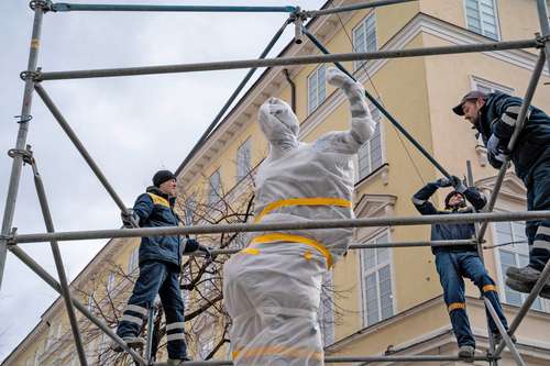 Cada vez más personas llegan a la estación de trenes inaugurada en 1904 en la ciudad ucrania de Leópolis en busca de huir hacia Polonia. En la imagen, trabajadores instalan protecciones a una estatua ante la proximidad de fuerzas rusas.