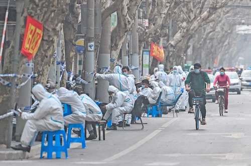  En Shanghai, China, se desplegó a varios trabajadores en los límites de las zonas confinadas para ayudar en las labores de contención del nuevo brote de coronavirus. Foto Afp