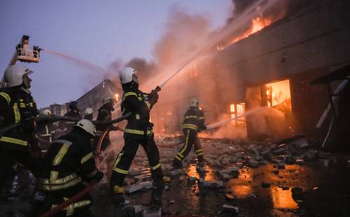  Bomberos intentan apagar el fuego en un depósito de Kiev luego de un bombardeo de las fuerzas del Kremlin. Foto Ap