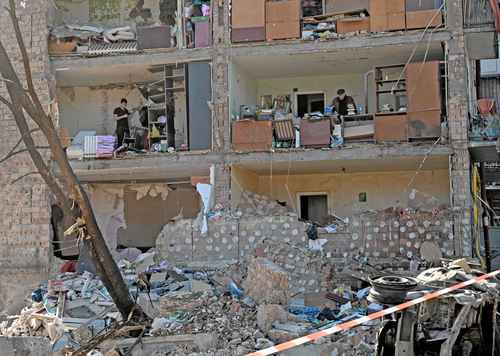 Residentes de un edificio destruido en la capital de Ucrania buscan rescatar lo poco que quedó de sus pertenencias.