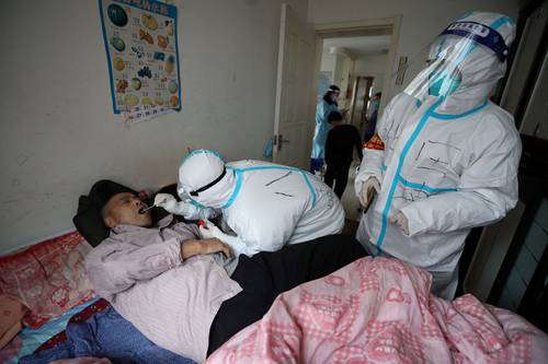  Ante el alza de casos, personal sanitario en China acude a tomar muestras a domicilio. Foto Afp