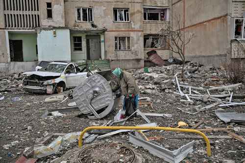 Una anciana busca chatarra entre los escombros de un edificio de departamentos dañado por la ofensiva rusa en un distrito de Járkov, hace un par de días.