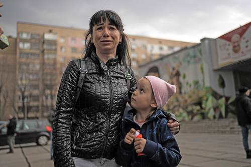 Julia, de 34 años, junto a su hija Veronika, de 6, solloza mientras habla con periodistas ayer en Brovary, en las afueras de Kiev, Ucrania.