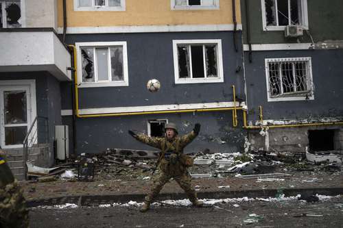 Entre la devastación causada por la guerra, un soldado ucranio juega con un balón en Irpin, a las afueras de la capital Kiev.