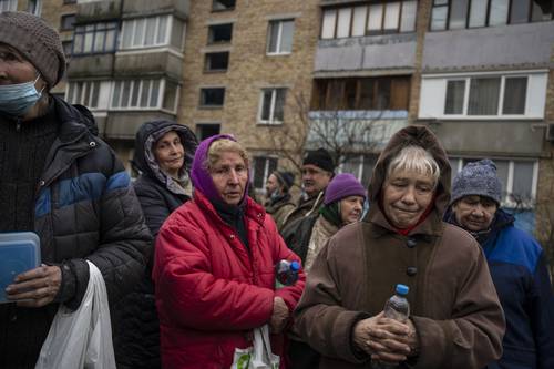 Un grupo de personas espera víveres en Bucha, a las afueras de Kiev.