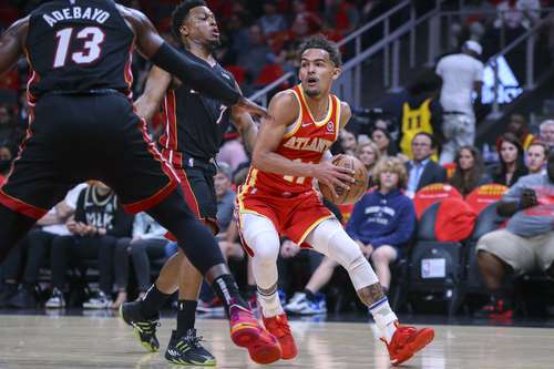 A la derecha Trae Young, de los Hawks, es defendido por el base Kyle Lowry (7).