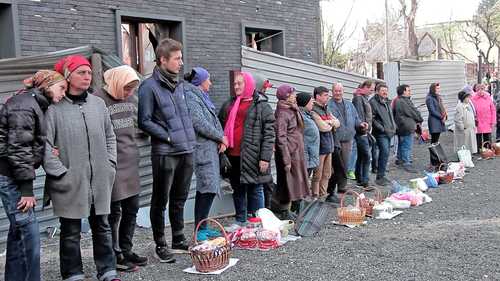 En imagen tomada de video, civiles esperan para la bendición de los pasteles tradicionales de Pascua y los huevos pintados para la celebración en la iglesia de San Alejandro Nevski, en Mariupol. El líder espiritual de los cristianos ortodoxos, Bartolomé I, pidió la apertura de corredores humanitarios en Ucrania.