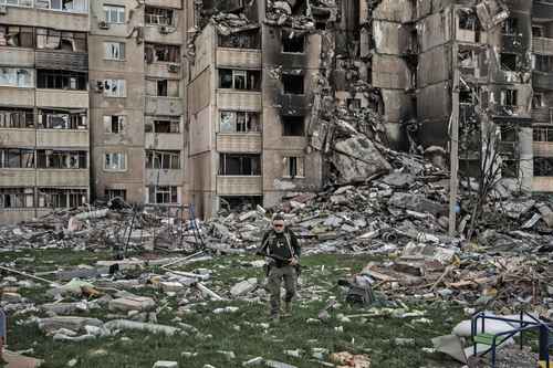 Un militar ucranio inspecciona una zona de Járkov bombardeada por los rusos.